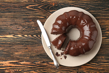 Plate with tasty chocolate cake and knife on table
