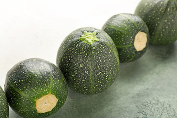 Fresh zucchini squashes on color background