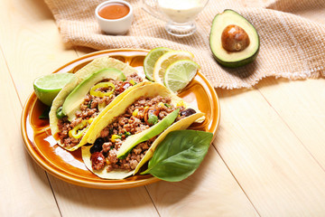 Plate with tasty fresh tacos on wooden background