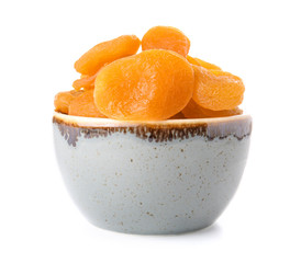 Bowl with dried apricots on white background