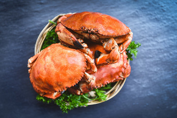 Cooked crab on steamer and dark background - Seafood boiled red stone crabs