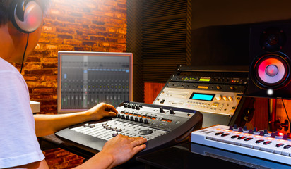 asian sound engineer mixing music in home recording studio. recording, broadcasting, editing, post production concept