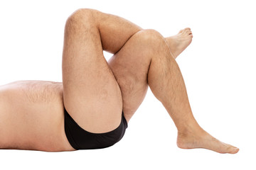 Men's hairy crossed legs. Excess weight. Close-up. Isolated on a white background.