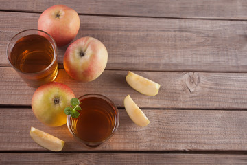 Apple juice and apples on wooden table. Selective focus