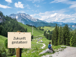 Zukunft gestalten Schild mit Frau in den Bergen