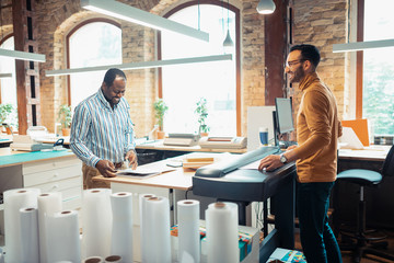 Obraz premium Two men using modern technology while working on book printing