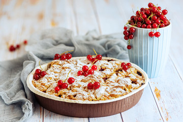 tasty homemade pie and Fresh red currants in light blue cup on light wooden table