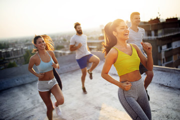 Group of happy fit friends exercising outdoor in city