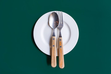 초록색 테이블 위에 올려진 접시, 숟가락, 포크