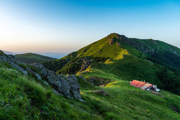 View of a mountain hut during sunrise in summer day