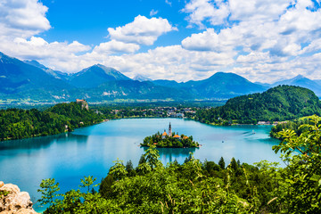 Fototapeta na wymiar Beautiful landscape of Lake Bled the church island in the middle and the castle in the background of white clouded sky from Ojstrica viewpoint in Bled, Slovenia