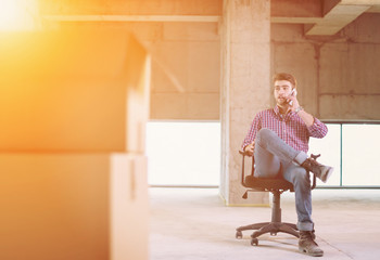 young casual businessman using mobile phone on construction site