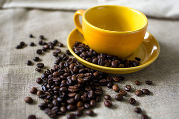 cup of coffee with beans on wooden table