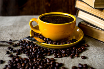 cup of coffee with beans on wooden table