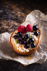 Baked pear with honey, cottage cheese, raspberries and currants. Fresh homemade dessert. Food composition in a low key. Close-up, copy space.