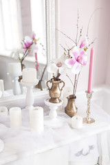 Delicate and light decoration of the dressing table with flowers, candles. Soft focus. Close up.