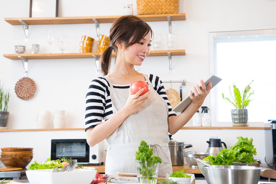 キッチンで料理を作る若い主婦