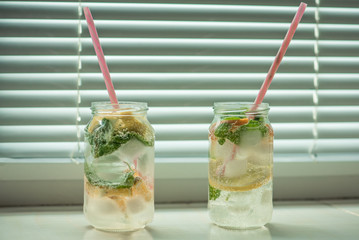 non-alcoholic summer drink with lemon, orange ice, on a light background, high key 