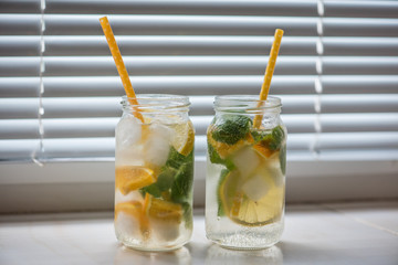 non-alcoholic summer drink with lemon, orange ice, on a light background, high key 