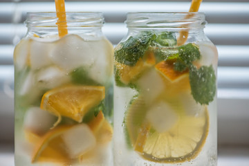 non-alcoholic summer drink with lemon, orange ice, on a light background, high key 