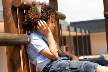 Schoolgirl listening music on headphones in the school playground