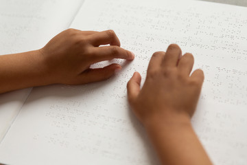 Blind schoolboy hands reading a braille book in classroom - obrazy, fototapety, plakaty
