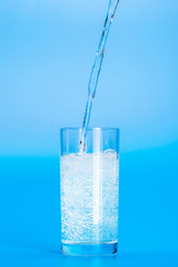 Close up pouring purified fresh drink water from the bottle on table