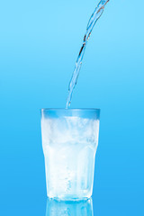 Close up pouring purified fresh drink water from the bottle on table