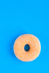 Close up of  classic donut with sugar on blue modern background. Copy space