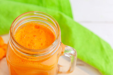 Glasses of carrot juice with vegetables on table close up