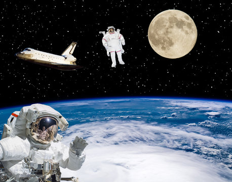Astronauts flying in outer space. Moon on the backdrop. Space scene. The elements of this image furnished by NASA.
