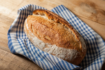 A loaf of fresh bread on a wooden table. Top view with copy space.
