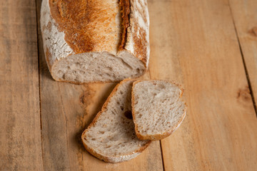 Fresh bread slices on a wooden table. View from above