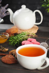 glass teapot with cup of black tea on wooden table
