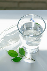 Glass of water with a bottle on table