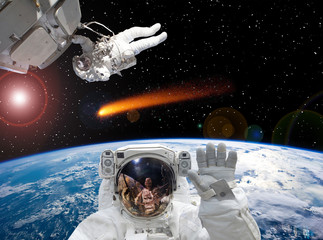 Astronaut waving. Other astronaut on the backdrop. Space scene. The elements of this image furnished by NASA.