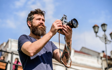 Man with long beard shooting photos. Manual settings. Photographer hold vintage camera. Modern...