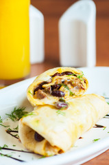 Two homemade burritos in a white plate.