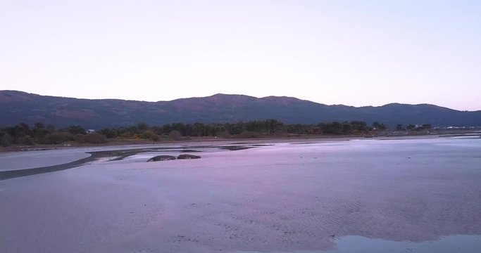 Sunset at a stunning Galician beach with a river estuary and a forest nearby n8