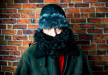 Naklejka premium Steampunk man with beard, hat and glasses on background of vintage brick wall