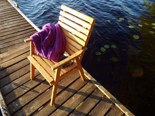Fototapeta na wymiar Swimming gear - robe and a mask on a jetty on the lake in the summer.