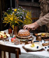 beautiful outdoor still life in country garden with bundt cake on wooden stand on rustic table