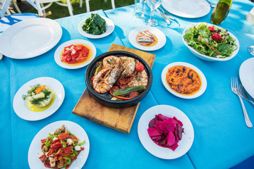Shrimp, Seafoods, appetizers and salads on the table in Fish Restaurant. Beach Restaurant in Greece or Turkey. Aegean seaside, Greek or Turkish style fish restaurant in Bodrum, Santorini or Mykonos