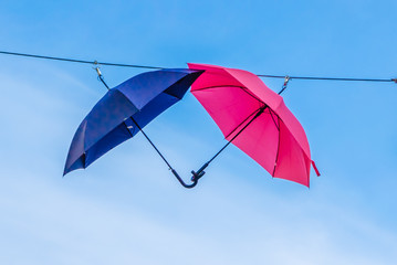 two umbrellas blue and pink together