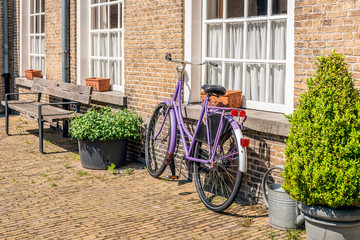 Fototapeta na wymiar Violet ladies bike against a brick wall
