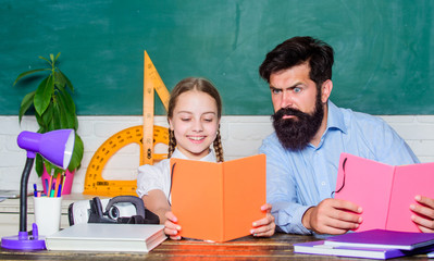 Concentrated on studying. small girl child with bearded teacher man in classroom. daughter study...