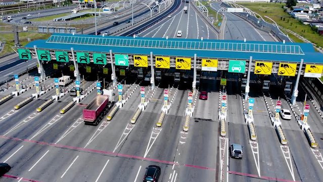 Toll roads on the broad highway. Through the point passes a large number of trucks and cars. Top down view of a quadcopter