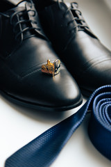 shoes, tie and cufflinks on a light background