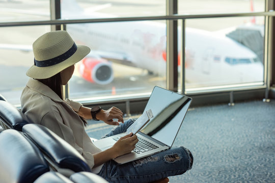 asian woman looking her watch for checking time to boarding at airport
