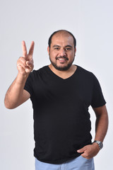 Fototapeta premium latin man with finger in the shape of number two